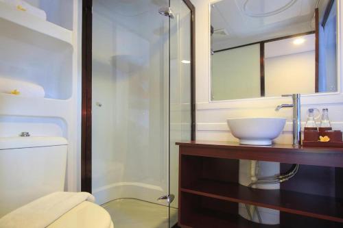 登巴萨Mars City Hotel的一间带水槽和玻璃淋浴的浴室