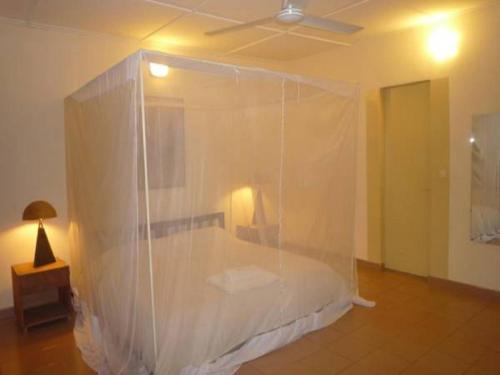 瓦加杜古Villa Yiri Suma的一间卧室,床上铺有塑料面纱