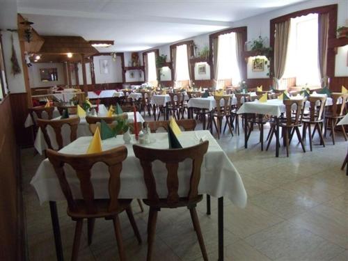托特莫斯Europäisches Gäste- und Seminarhaus的餐厅内带桌椅的用餐室