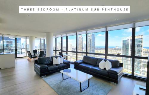 墨尔本Melbourne Lifestyle Apartments – Best Views on Collins的客厅配有沙发和桌子