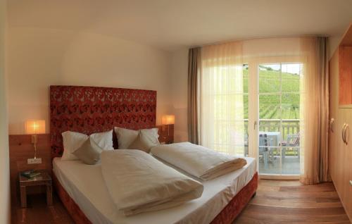 泰尔梅诺Überbacherhof的一间卧室设有一张大床和一个大窗户