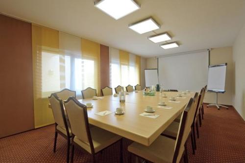 格里斯海姆诺斯德杰尔咖啡馆酒店的大型会议室,配有长桌子和椅子