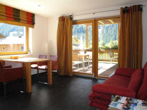 朗根费尔德Ferienwohnungen Vier Jahreszeiten的一间带桌椅的客厅和一个阳台