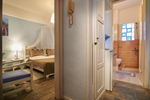 新马尔马拉斯希腊之家酒店的一间卧室配有一张床,浴室设有卫生间