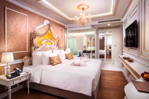 曼谷Amaranta Hotel - SHA Plus的卧室配有一张白色大床和吊灯。