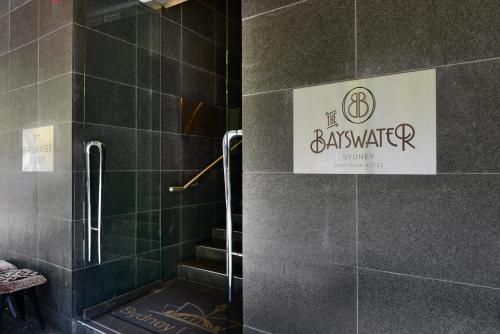 悉尼悉尼贝斯沃特酒店的带淋浴的浴室和墙上的标志