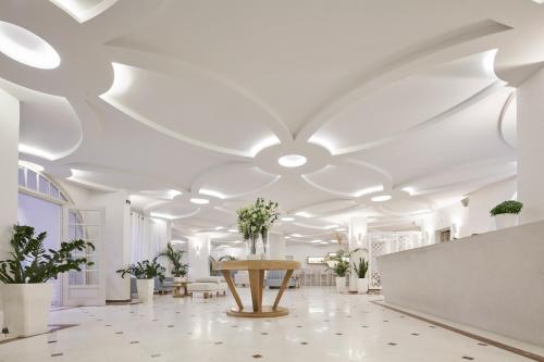 费拉桑托瑞尼酒店的白色的房间,配有桌子和盆栽植物