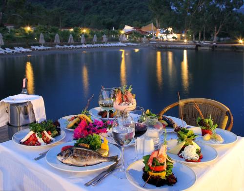 希萨勒尼Fortezza Beach Resort的水边的餐桌上放着食物