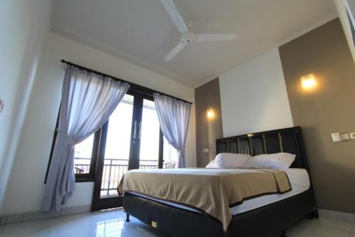 库塔小村庄旅馆的一间卧室设有一张床和一个大窗户