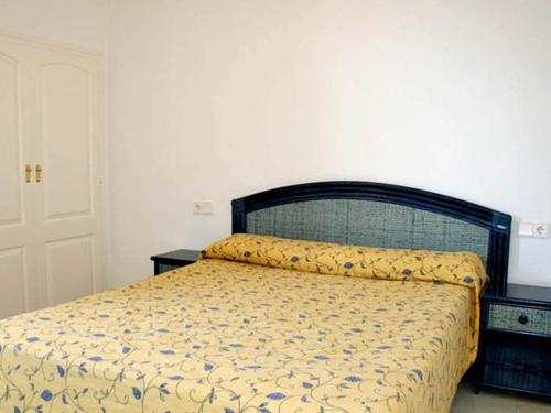 卡尔佩优尼图尔萨蓝宝石公寓的一间卧室配有一张黄色和蓝色的床罩