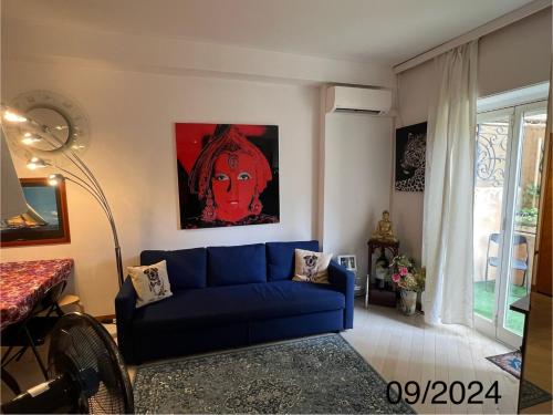 蒙特卡罗Very Central suite apartment with 1bedroom next to the underground train station Monaco and 6min from casino place的客厅配有蓝色沙发和绘画作品