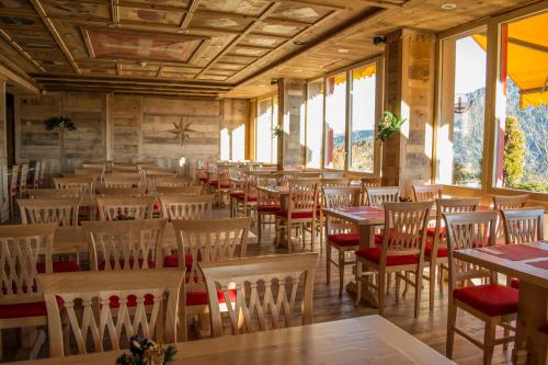 莱森阿尔卑斯经典酒店的用餐室设有桌椅和窗户。