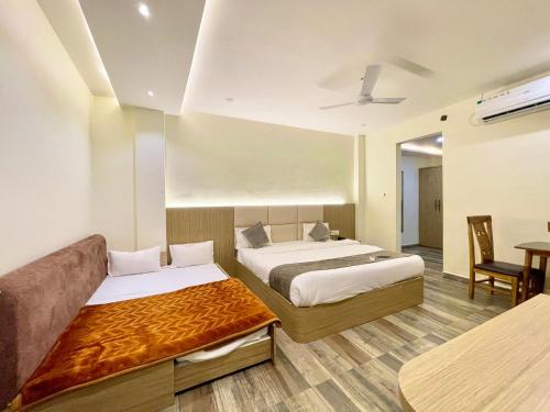 乌贾因HOTEL PRAKASH INN ! UJJAIN होटल प्रकाश fully-Air-Conditioned hotel at prime location with wifi & Parking availability, Newly constructed and Luxurious Rooms的酒店客房,设有两张床和一张沙发