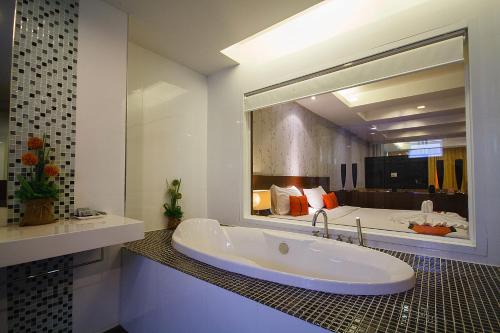 芭东海滩铂金公寓及酒店的一间带浴缸和大镜子的浴室
