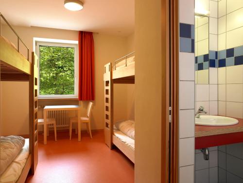 卢森堡卢森堡市青年旅舍的客房设有双层床、水槽和桌子。