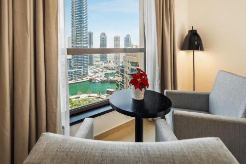 迪拜Brand new Spacious, Deluxe, 5BR plus maidroom on JBR walk Next to Beach ,Tram & Mall by La Buena Vida Holiday Homes的客房设有桌椅和窗户。