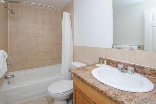 伦敦安大略省伦敦旅馆的浴室配有盥洗盆、卫生间和浴缸。