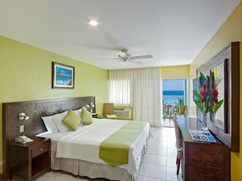 布里奇敦椰子园海滩酒店的一间卧室配有一张床,享有海景