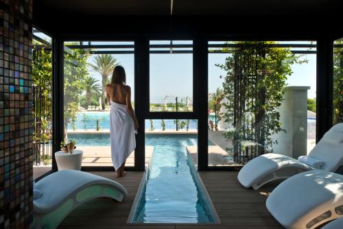 奥斯图尼玛赛丽亚圣塔卢西亚大酒店的身着白色衣服的女人站在游泳池旁