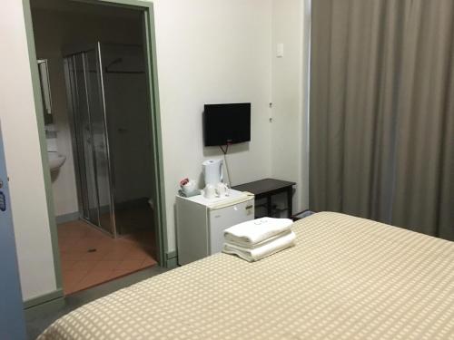 达博达博阿马罗酒店的一间卧室配有一张床、一台电视和一间浴室。