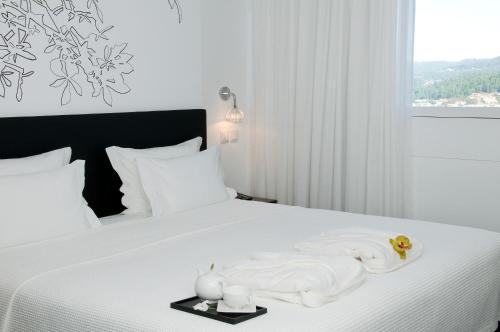 吉马良斯开房村体育温泉酒店的一间卧室配有带毛巾的床