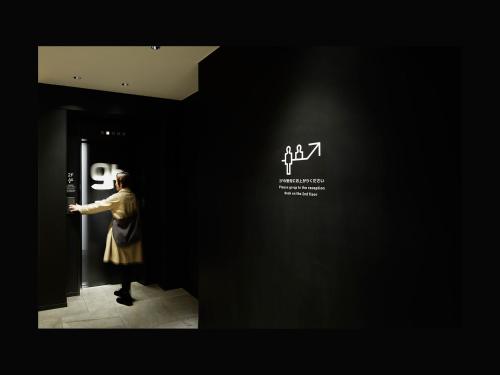 仙台9h nine hours Sendai的站在走廊上看着博物馆里的海报的女人