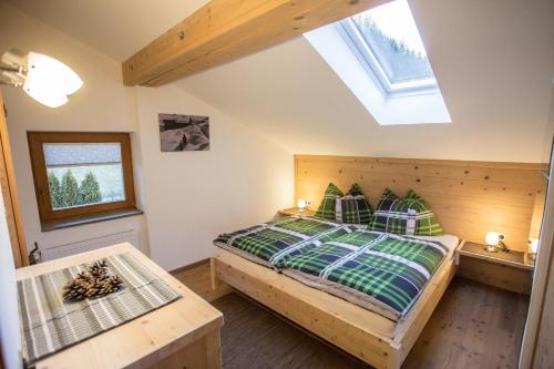 AußervillgratenFerienwohnung Walder的一间卧室设有木床和天窗