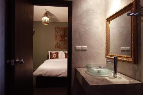 清迈理路清迈酒店的一间带水槽、床和镜子的浴室