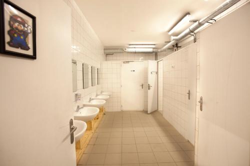 里昂漫游者宾馆的浴室设有4个水槽和一排卫生间