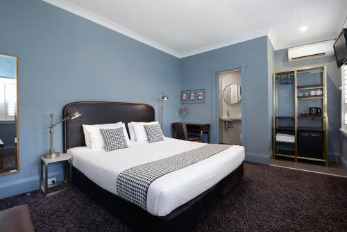 悉尼小别墅酒店的一间卧室配有一张带蓝色墙壁的大床