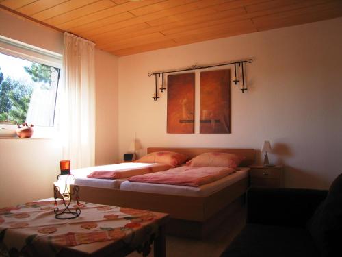 库克斯港Haus Witten Höhen的一间卧室设有两张床、一个窗口和一张桌子