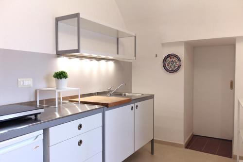 马萨夫拉B&B Corte Laterza的厨房配有白色橱柜和水槽