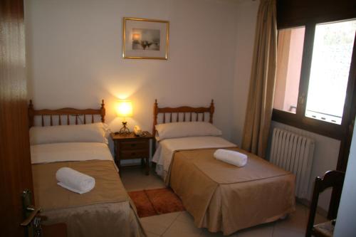 奥尔迪诺加斯帕酒店的一间卧室设有两张床、一盏灯和一扇窗户。