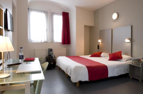 鲁瓦昂地区蓬水音乐酒店的酒店客房设有一张大床和一张书桌。