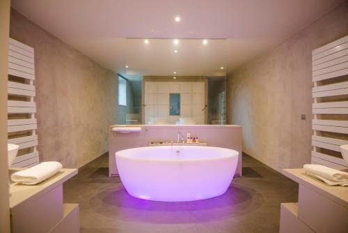 那慕尔奈特水疗酒店的一个带水槽的浴室内的白色大浴缸
