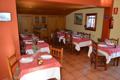 比克萨塞瑞Hotel Parador de Canolich - Only Adults的餐厅配有桌椅和红白桌布