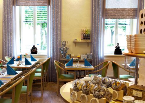 柏林梅拉罗斯·芬·舒酒店的餐厅设有桌椅和窗户。