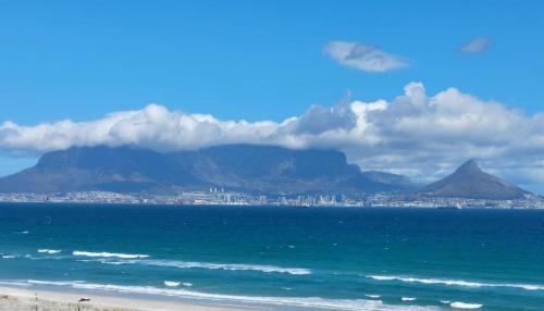 布鲁堡史特兰Cape Town Beachfront Accommodation in Blouberg的海滩上可欣赏到Cape镇和桌山的景色