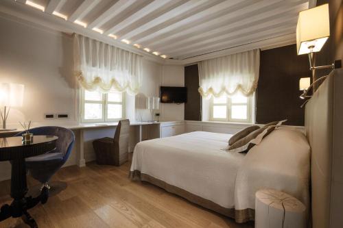 卢卡阿尔伯格席琳酒店的卧室配有白色的床、书桌和椅子
