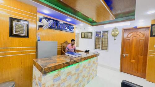 达卡Hotel Prime Inn Mirpur 10的坐在餐厅酒吧的女人