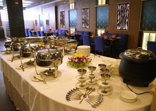 阿加尔塔拉Hotel Sonar Tori的餐厅的桌子上摆放着盘子和餐具