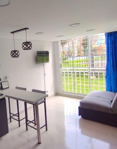 波哥大apartamento en Bogotá cerca a Corferias, embajada, americana, universidad nacional y centro historico的客厅配有桌子和沙发