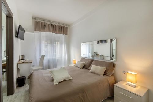 卡利亚里赛特科利宾馆的一间卧室配有一张大床和镜子