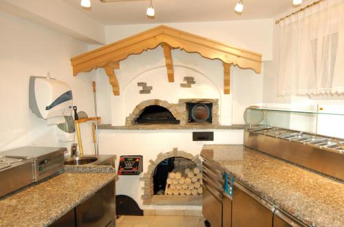 拉辛Residence Priska的厨房的墙上设有大型比萨饼烤箱