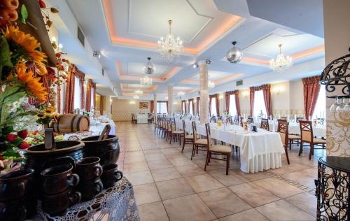 比亚韦斯托克Hotel POD HERBEM -POKOJE OZONOWANE的宴会厅配有白色的桌椅和吊灯