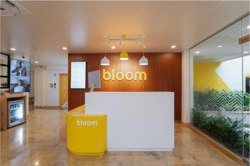 肯达拉Bloom Hotel - Lonavala Khandala的大堂设有黄色和白色的柜台和标志