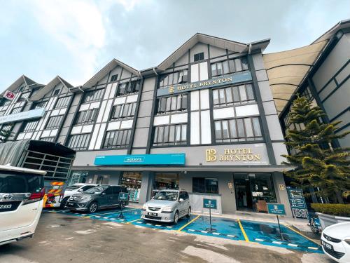 金马仑高原Hotel Brynton at Centrum的停车场内停放汽车的大型建筑