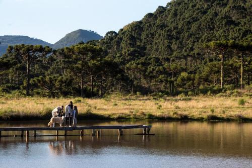 乌鲁比西Parque Nacional EcoResort的两个人和水面上的一只狗