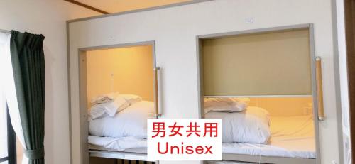 大阪HOSTEL198 Unisex dormitory cabin typeーVacation STAY68082v的配有一张床铺的客房内的两面镜子