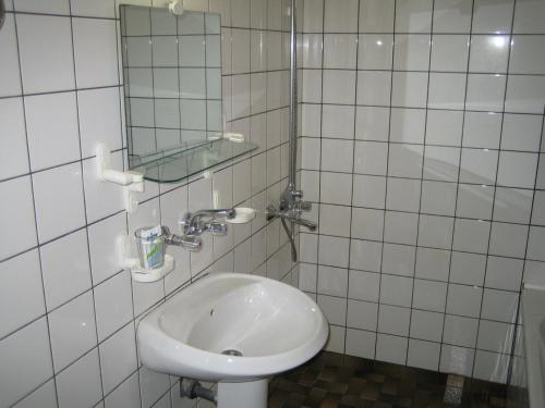 阿巴纳西阿伴纳斯酒店的白色瓷砖浴室设有水槽和镜子